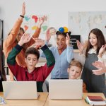 Estudiantes y profesor celebrando juntos una actividad en clase. Fotografía ilustrativa.